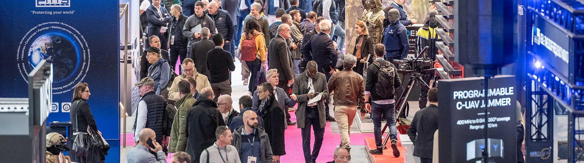 crowds of visitors strolling the aisles of the Milipol Paris trade fair