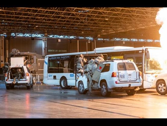 Tactical intervention demonstration at Milipol Paris 2025 showing GIGN units approaching a bus during a simulated operation in the Demo Arena.