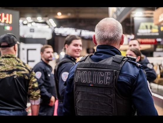 Police officers interacting on the exhibition floor at Milipol Paris 2025, highlighting operational engagement and professional exchange.