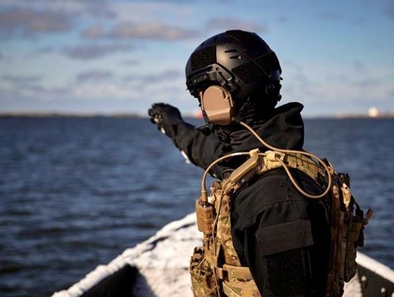Tactical operator equipped with a communication headset during a maritime operation