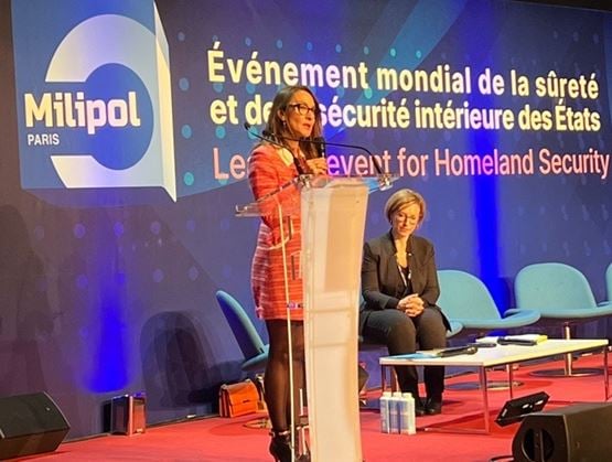 Speaker addressing the audience during a conference session on cold cases at Milipol Paris, with the Milipol Paris stage and branding in the background.