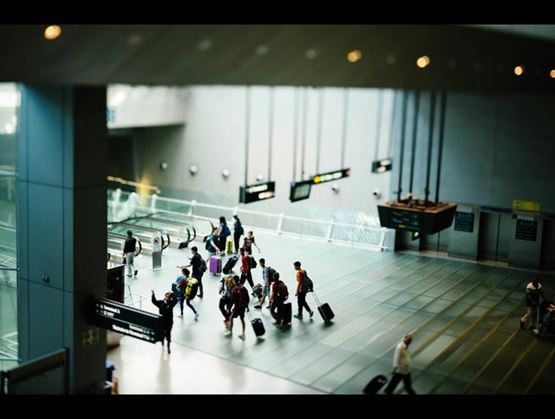 Vue d'un terminal d'aéroport avec des passagers munis de valises pour symboliser la gestion numérique des frontières – systèmes de contrôle douanier biométriques et fondés sur les données