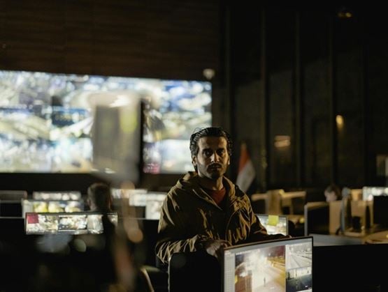 Security operator monitoring multiple CCTV feeds in a command centre during a video surveillance operation