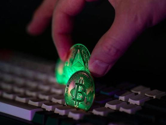 Pièces de cryptomonnaie posées sur un clavier, illustrant la cybercriminalité financière et le vol d'actifs numériques.