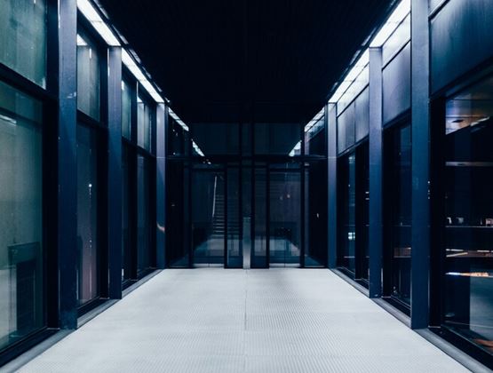 Interior of a modern data centre with rows of server racks and illuminated technical infrastructure.