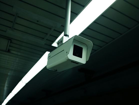 Security surveillance camera mounted on an indoor ceiling.