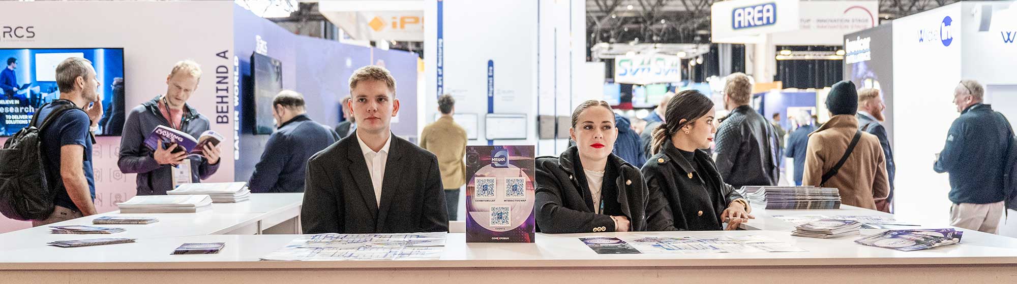 Two hostesses and a host at the show information desk