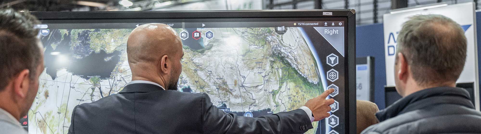 Man pointing at a large interactive screen, engaging with the technology