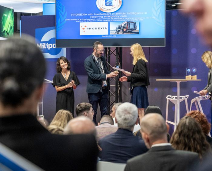 Lauréate d'un Milipol Innovation Awards sur scène de l'Innovation Stage, recevant un trophée des mains des organisateurs devant un parterre de visiteurs durant Milipol Paris