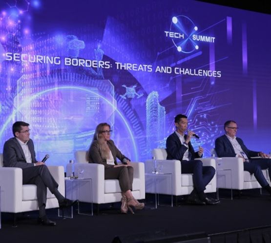 4 hommes assis sur la scène de la salle des conférences lors de l'événement Milipol Asia Pacific
