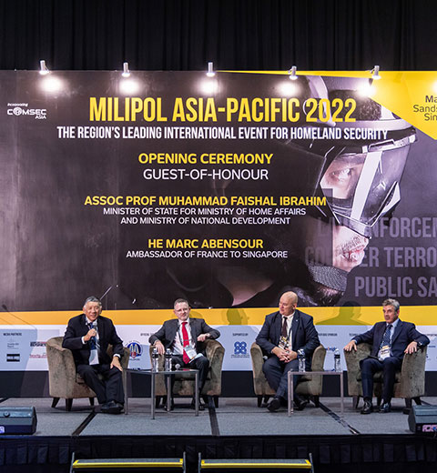 4 hommes assis sur la scène de la salle des conférences lors de l'événement Milipol Asia Pacific