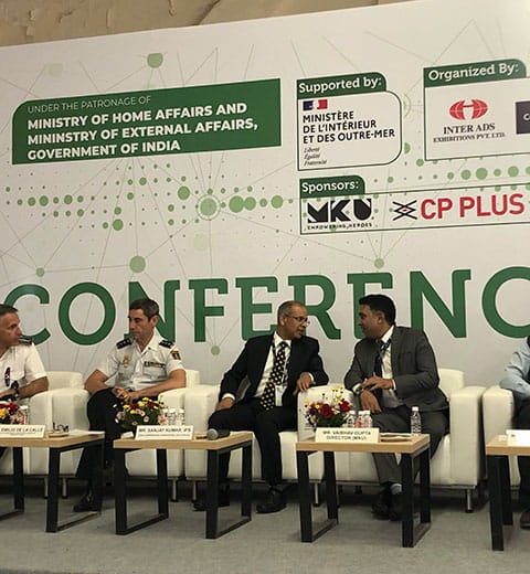 5 men seated on stage in the conference room at the Milipol India event, two of them are in uniform