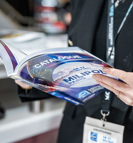 Zoom sur une personne feuilletant le catalogue Milipol Paris