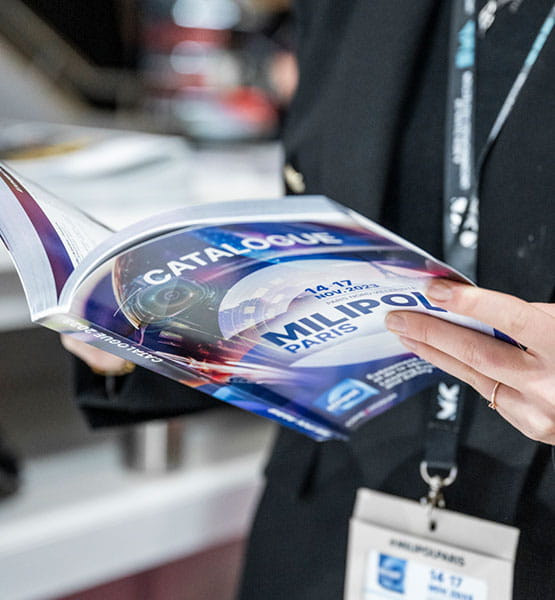 Zoom on someone leafing through the Milipol Paris catalogue