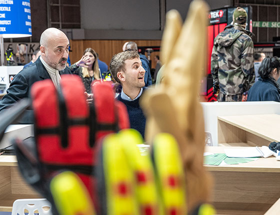 Exhibitor specialised in protective gloves smiling at someone