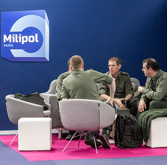 4 hommes en uniforme discutent attablés au sein du lounge VIP/DO