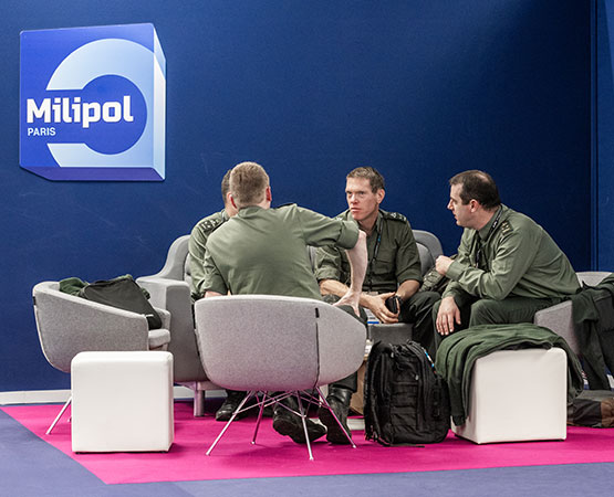 4 hommes en uniforme discutent attablés au sein du lounge VIP/DO
